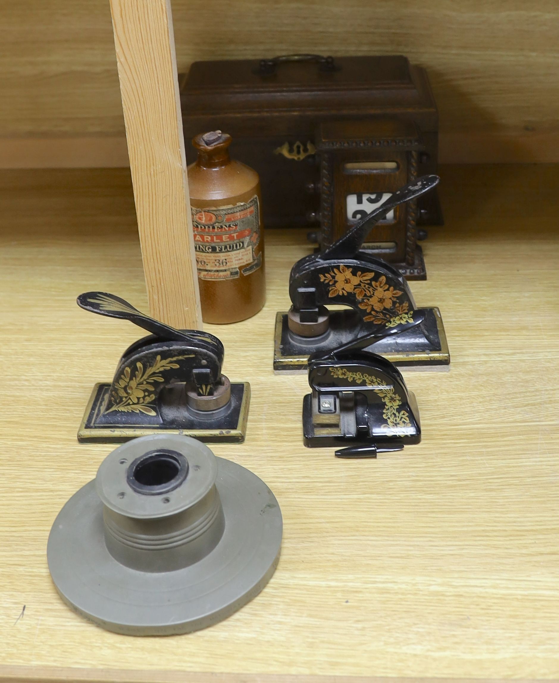 Three Victorian style desk embossing stamps, a terracotta bottle of Stephens 'Scarlet Writing Fluid', a desk calendar, oak box and a desk stand
